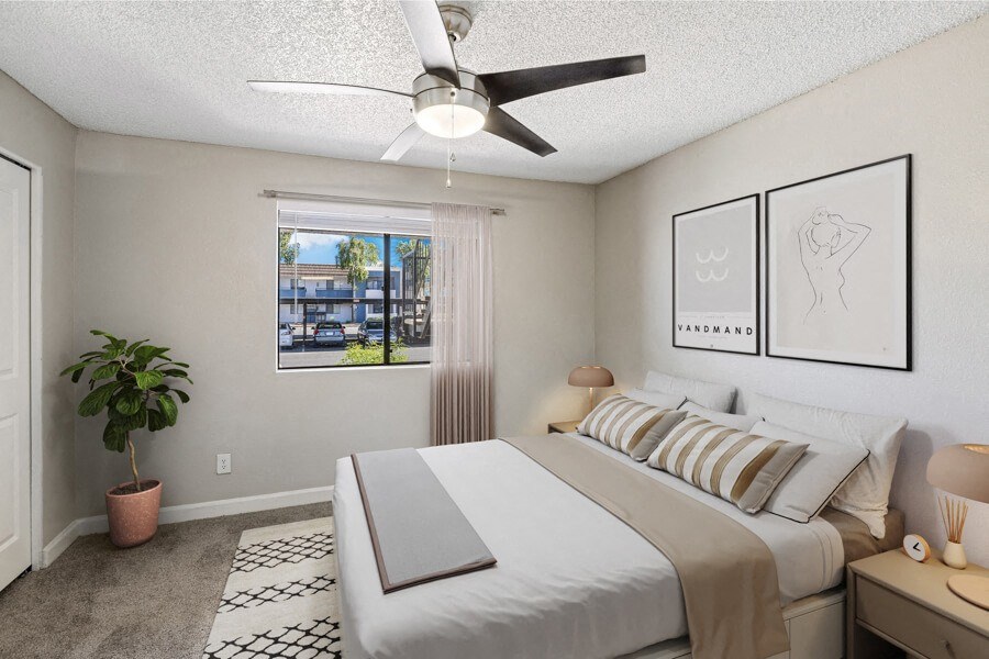 a bedroom with a large white bed and a ceiling fan